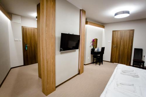 a room with a bed and a tv on a wall at Bulwary Biznes in Mielec