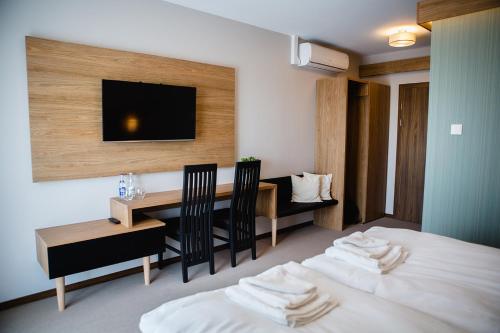 a hotel room with a bed and a table and a television at Bulwary Biznes in Mielec