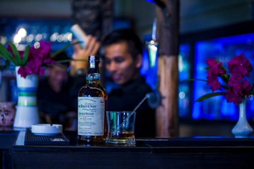 a bottle of whiskey sitting on a table with a glass at Shambaling Boutique Hotel in Kathmandu