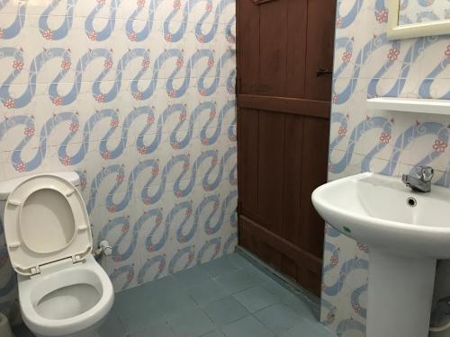 a bathroom with a toilet and a sink at Nice Place Beach Hotel in Arugam Bay