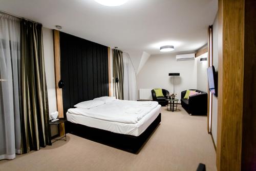 a hotel room with a bed and a chair at Bulwary Biznes in Mielec