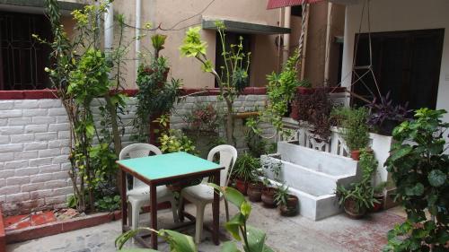 a patio with a table and chairs and plants at Silver Moon Guest House in Mahabalipuram