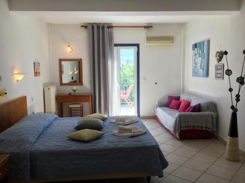 sypialnia z niebieskim łóżkiem i kanapą w obiekcie KTM Sunny Villas w Poros