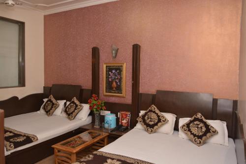 a room with two beds and a table at Hotel Yatri International in New Delhi