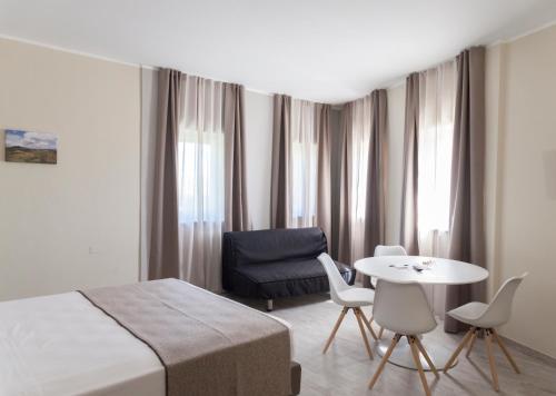 a hotel room with a bed and a table and chairs at Hotel & Wellness Stella Delle Langhe in Govone