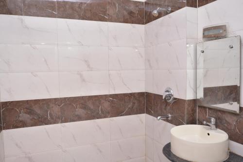 a bathroom with a white sink and a shower at Hotel Yatri International in New Delhi
