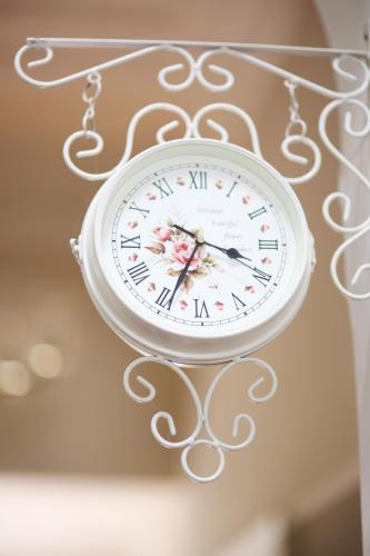 a white clock hanging from a metal wall at Oleander Guest House in Kimberley