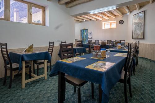un comedor con mesas y sillas azules en Siala Guest House, en Leh