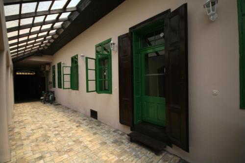 a row of green doors on the side of a building at Rooms Lišnić in Osijek