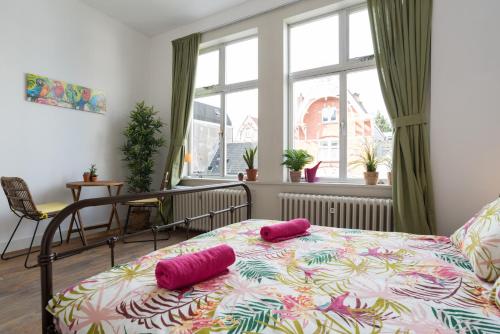 a bedroom with a bed with two pink pillows on it at Stir It Up Studio in Amsterdam