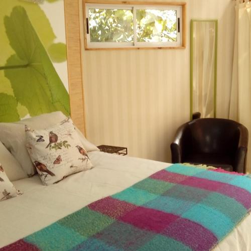 a bedroom with a bed with a chair and a window at Organica Lodge Hotel Boutique in Vicuña