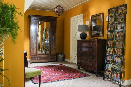 a living room with a dresser and a mirror at Farmhouse De Hoeve B&B apartment in Tonden