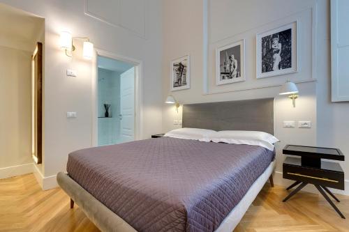 ein Schlafzimmer mit einem großen Bett und einem Schreibtisch in der Unterkunft TAILOR HOUSE B&B in Florenz