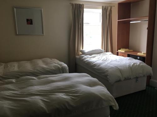 two beds in a hotel room with a window at The Bridge View in Runcorn