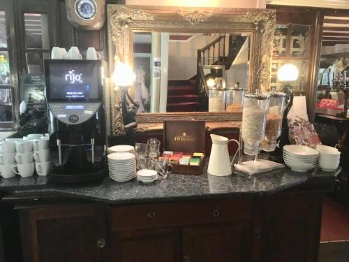 a counter with a coffee machine and a mirror at The Beaufort, Raglan in Raglan