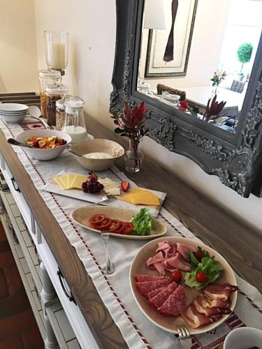 a buffet with plates of food on a table at Oude Berg Guesthouse - 10 Caledon Street in George