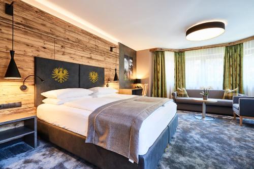 a hotel room with a large bed and a couch at Der Postwirt in Söll