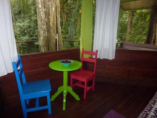 a table and chairs in a room with a window at Finca Valeria Treehouses Glamping in Cocles