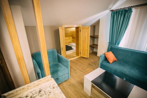 a living room with a blue couch and a mirror at Turkuaz Apart in Uzungöl