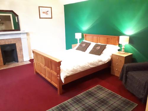 a bedroom with a large bed and a fireplace at Rigg House B&B in Kirkconnel