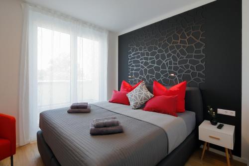 a bedroom with a large bed with red pillows at Penthouse-Appartements Freiburg in Freiburg im Breisgau