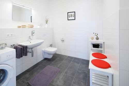 a white bathroom with a toilet and a sink at Penthouse-Appartements Freiburg in Freiburg im Breisgau