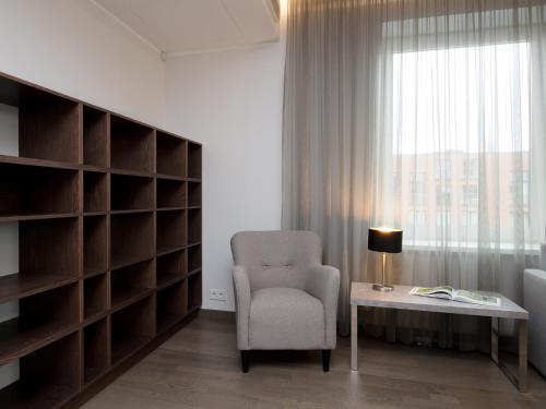 a room with a chair and a table and a window at 8ERA Business Executive Rotermanni Apartments in Tallinn