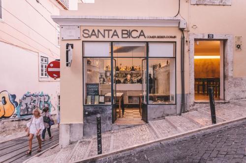 Ein kleines Mädchen, das vor einem Santa Bva Laden läuft. in der Unterkunft Santa Bica Eat Drink & Sleep in Lissabon