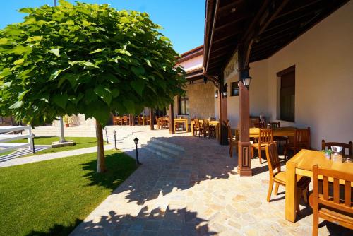 a patio with tables and chairs and a tree at Boutique Complex Trakiets in Zhitnitsa
