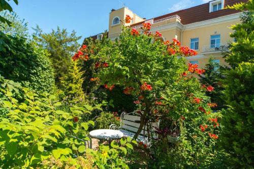 a garden with a table and flowers in front of a building at Palace Del Mar in Odesa