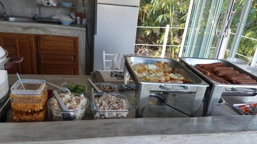 a kitchen counter with a stove and some food at C-HILL@KHAOKHO in Khao Kho