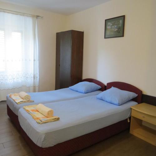 two beds in a room with blue pillows at Rooms Garden in Dubrovnik