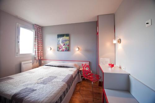 a small bedroom with a bed and a desk at La Grange de Marie in Nitry