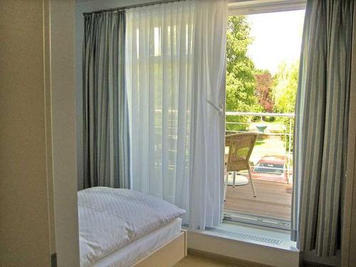 プレローにあるFerienhaus Sundevit Nr 1 Prerowのベッドルーム1室(パティオの景色を望む窓付)