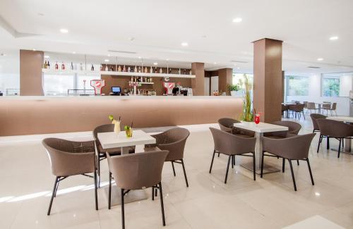 um restaurante com mesas e cadeiras e um bar em Globales Panamá em Palmanova