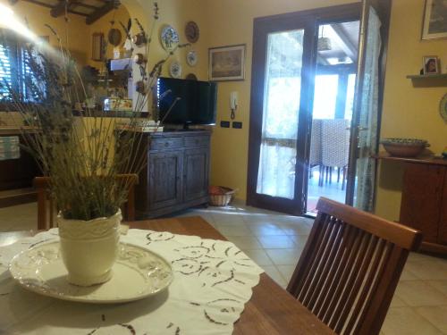 a dining room with a table with a vase on it at Villa Santa Margherita in Castelluzzo