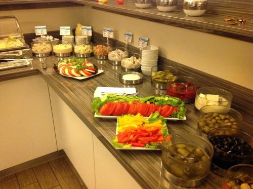 a counter with plates of vegetables and other foods at Ostseehotel Boltenhagen in Boltenhagen