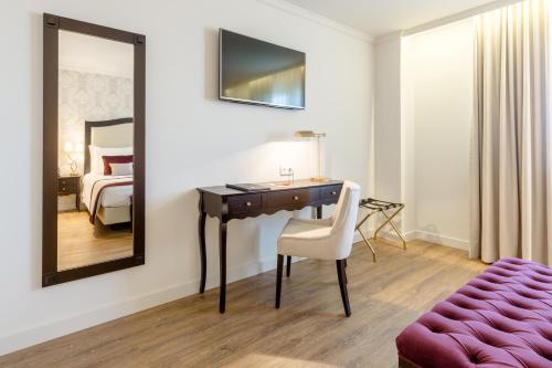 a room with a desk and a bed and a mirror at Luna Hotel Turismo in Abrantes