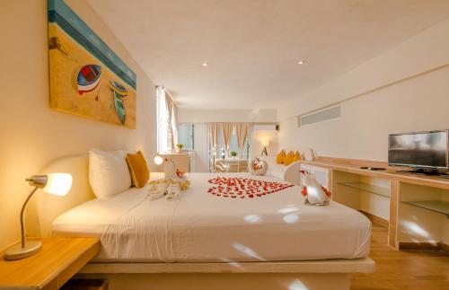 a bedroom with a large white bed with a desk at Casa Luca in Playa del Carmen