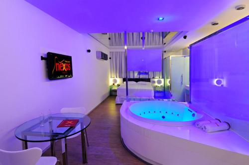 La salle de bains est pourvue d'une baignoire, d'une table et d'un lit. dans l'établissement Nexos Motel Piedade - Adults Only, à Récife