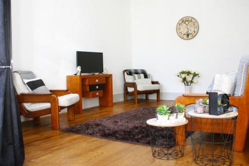 ein Wohnzimmer mit 2 Stühlen und einem TV in der Unterkunft Casa Azul d'Altamira in Viana do Castelo
