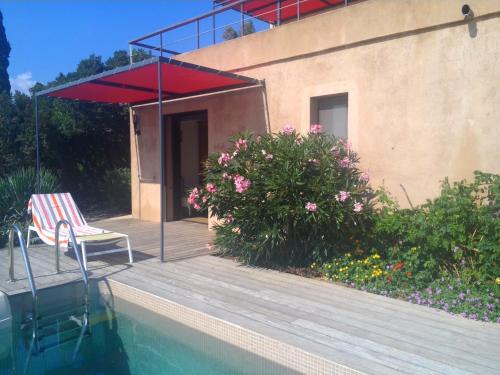 a swimming pool with a chair and a house at Villa Mirabel in Île du Levant