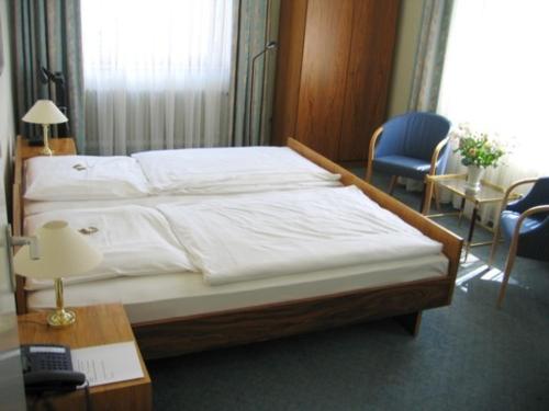 a bedroom with a large bed with white sheets at Gildenhof An den Westfalenhallen Dortmund in Dortmund