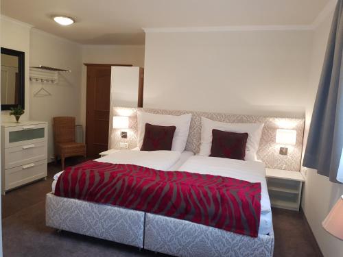 ein Schlafzimmer mit einem großen Bett mit einer roten Decke in der Unterkunft Appartements Basti in Forstau