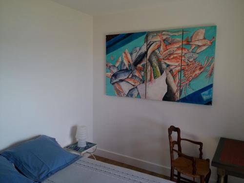a bedroom with a bed and a painting on the wall at Villa Mirabel in Île du Levant