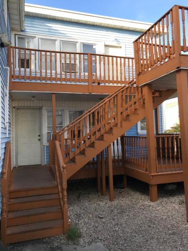 eine Holzterrasse mit einer Treppe vor einem Haus in der Unterkunft Shore Beach Houses - 40 - 2 Dupont Avenue in Seaside Heights