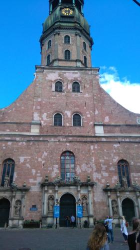 un edificio con una torre dell'orologio sopra di Apartment Kalku 2 a Riga