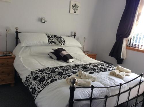 a bedroom with a bed with towels on it at Rudan Guest House AB53 6UQ in New Deer