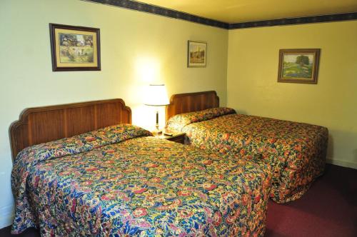 a hotel room with two beds in a room at Outpost Motel in Dripping Springs