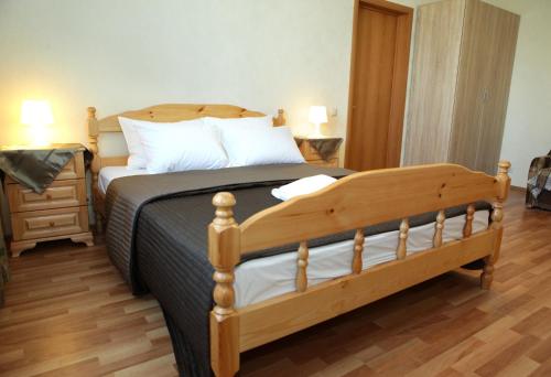 a bedroom with a wooden bed with a wooden floor at Apartment at Osenniy Bulevard 7 in Moscow